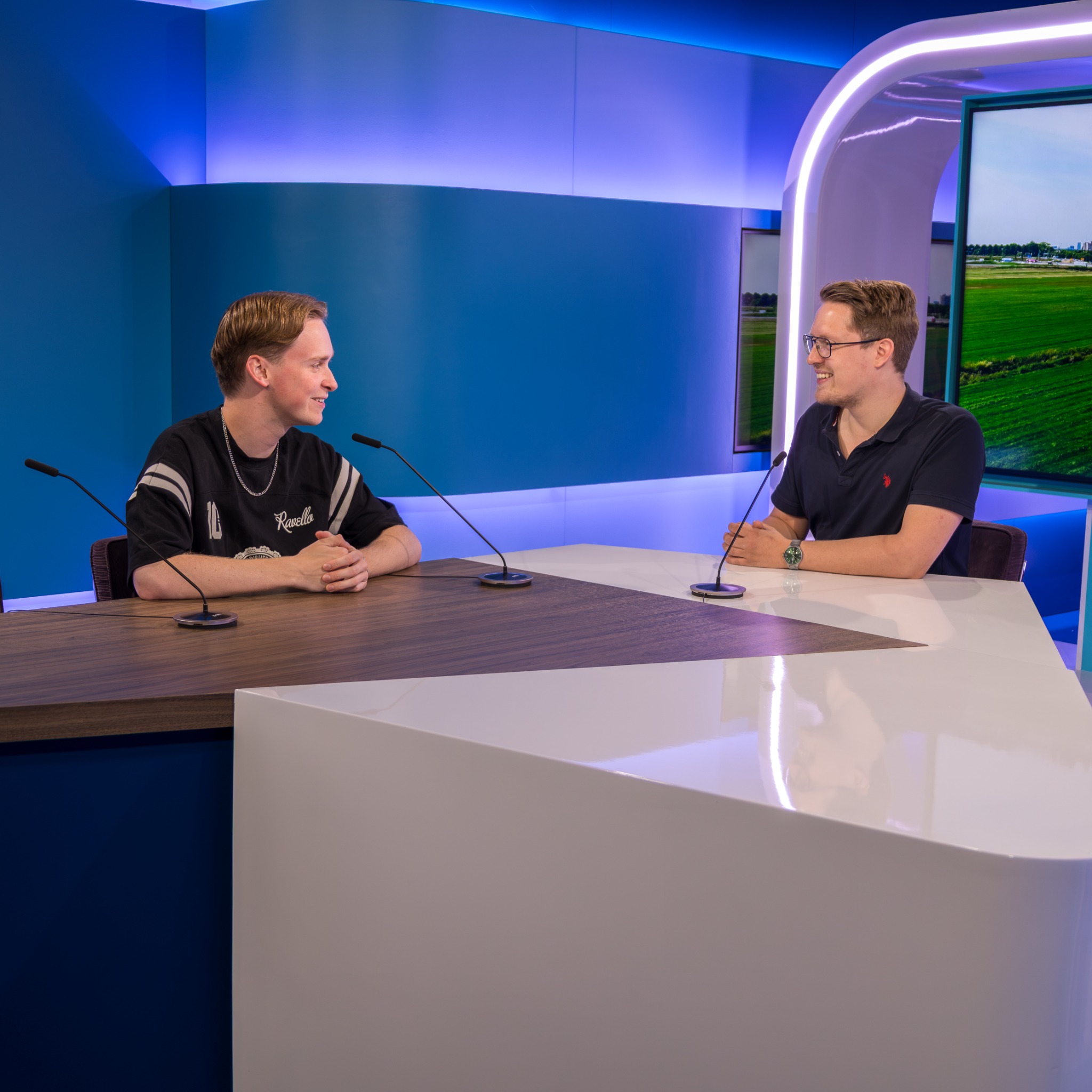 Een gesprek met twee gasten aan tafel in de televisiestudio van Dtv
